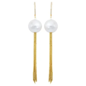 A pair of gold and pearl earrings with long chains.