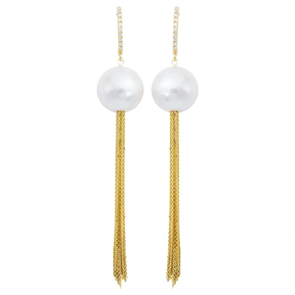 A pair of gold and pearl earrings with long chains.