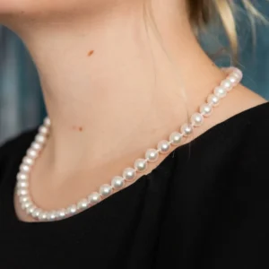 A woman wearing pearls in her neck.