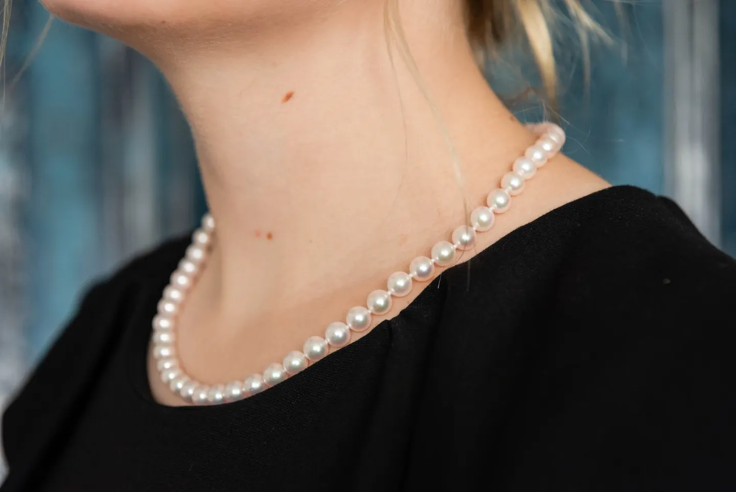 A woman wearing pearls in her neck.