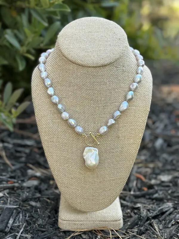 Gray pearl necklace with large pendant.