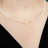 A woman wearing pearls and a gold necklace.