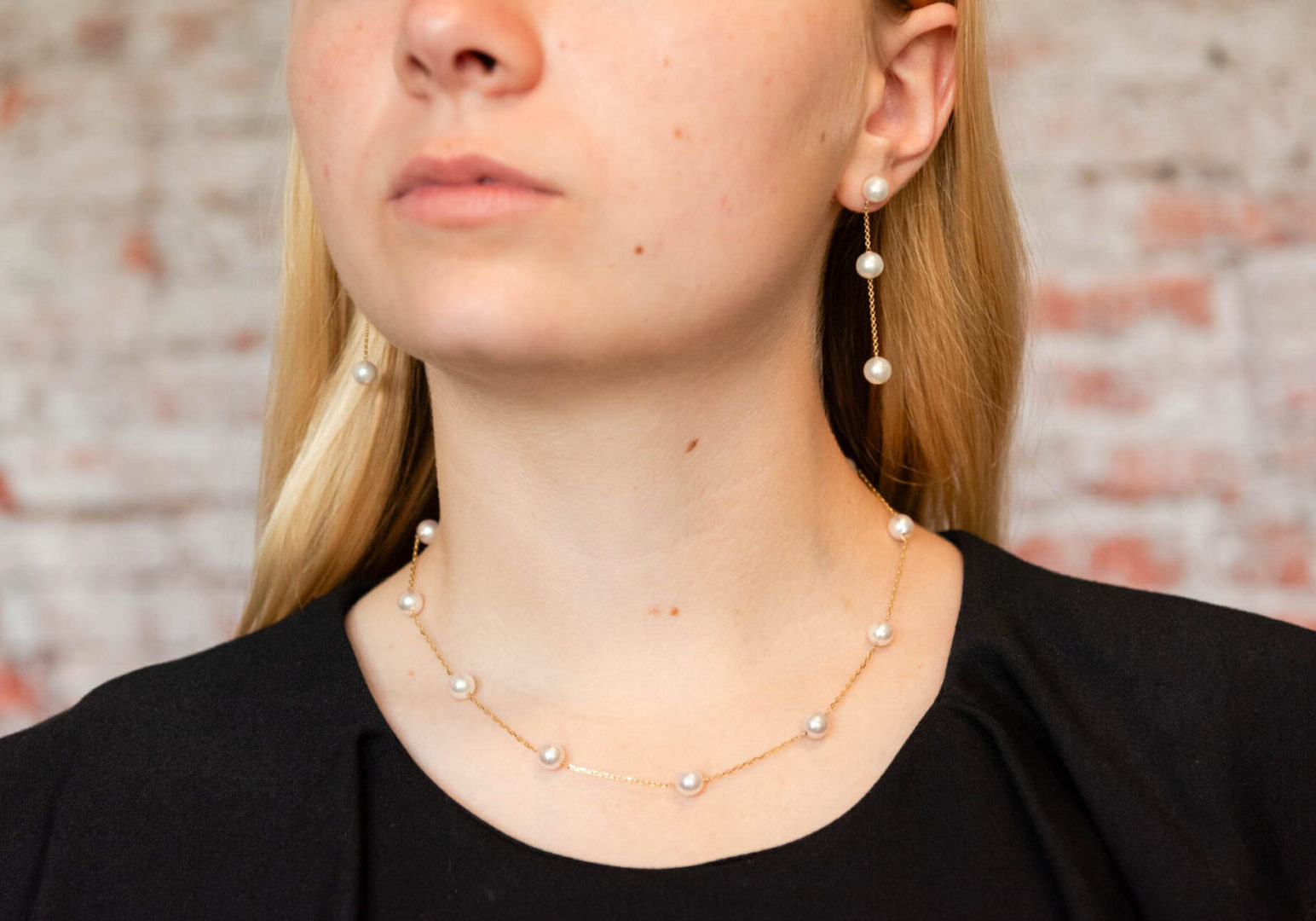 A woman wearing a necklace and earrings.